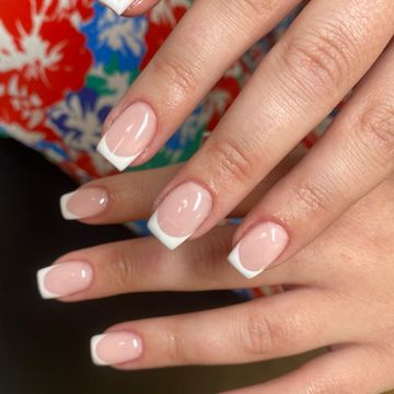 Glossy French tip nails with a soft pink base