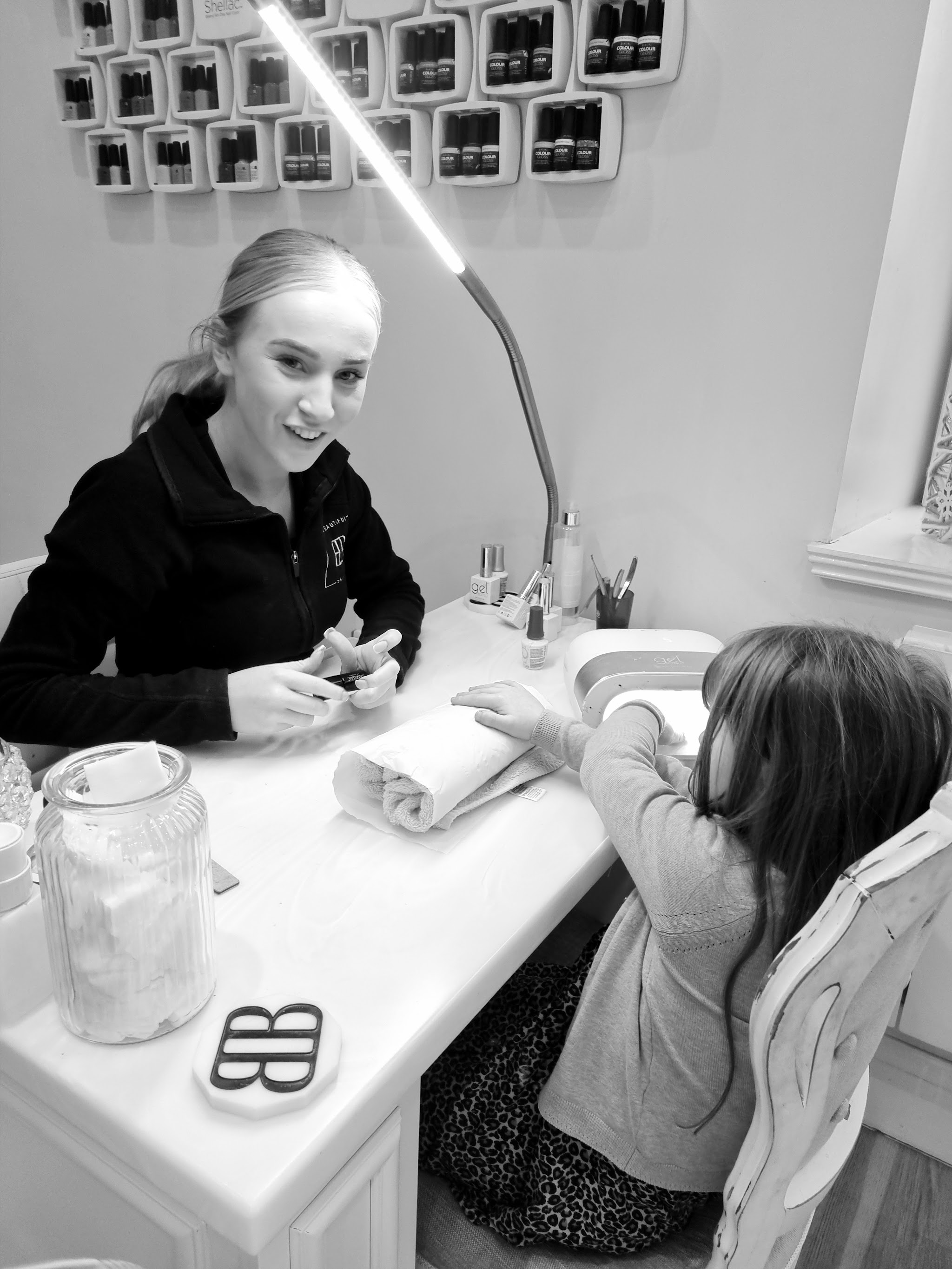 A Be Beautiful technician working with a client at the salon nail desk